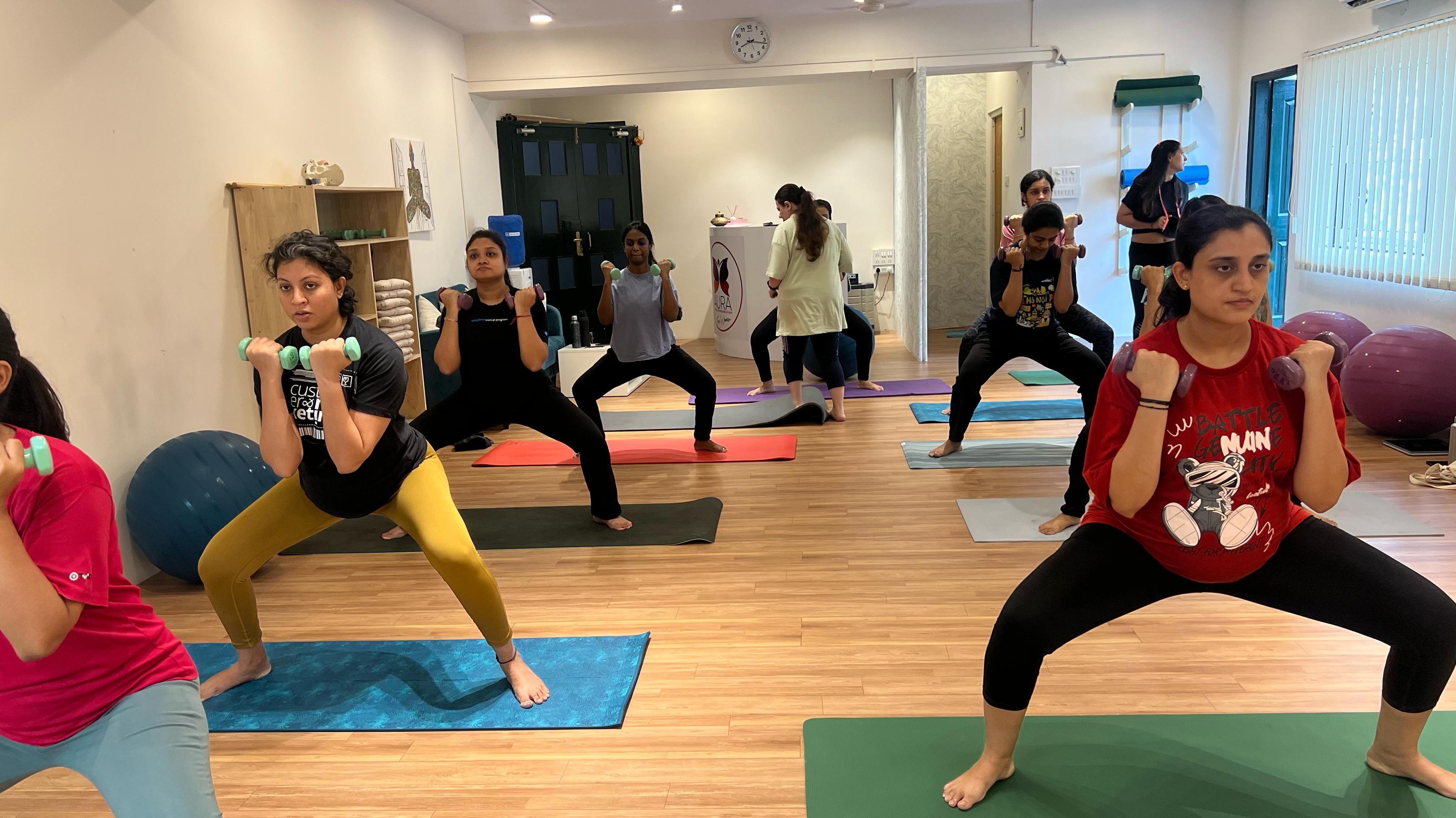 Women practicing yoga at Aura, fostering a healthy and mindful prenatal fitness routine.
